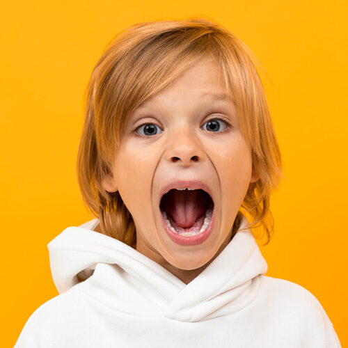 Young boy showing teeth with open mouth